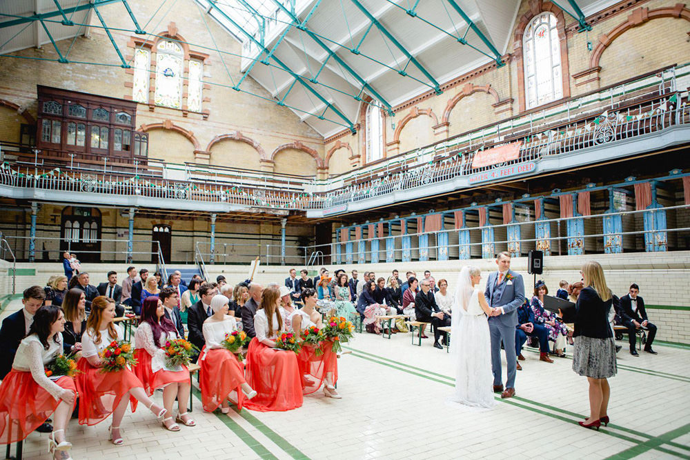 Ceremony in the main swimming pool at The Turkish Baths stained glass window at Victoria Baths Wedding Venue Manchester