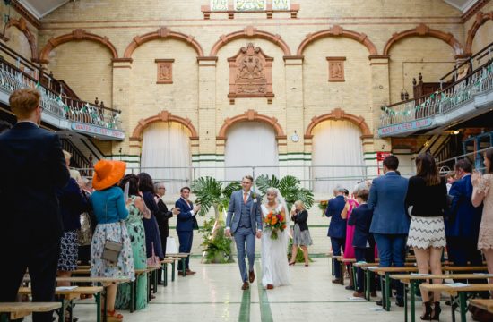 Couple walking down the aisle after wedding ceremony at Victoria Baths Manchester